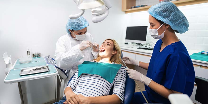 Hygienist and dentist performing a teeth cleaning