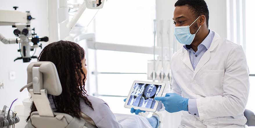 Dentist reviewing implant X-rays with a patient